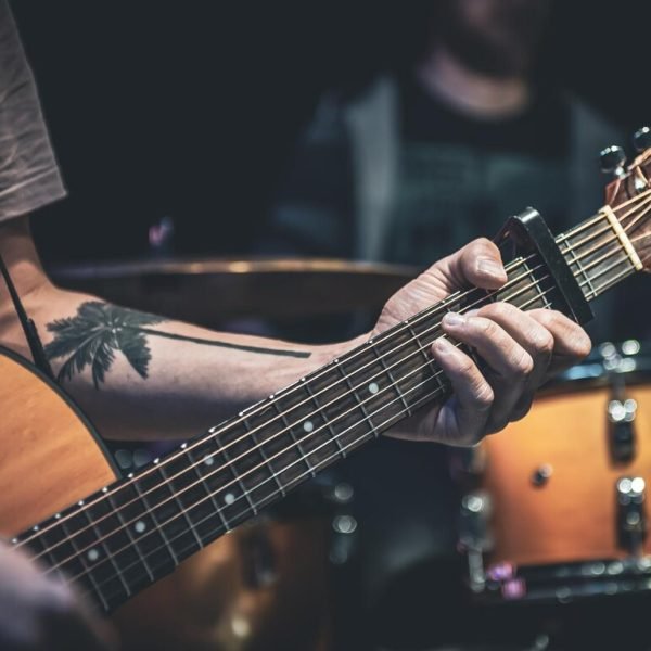 man-plays-acoustic-guitar-dark-closeup_169016-20698
